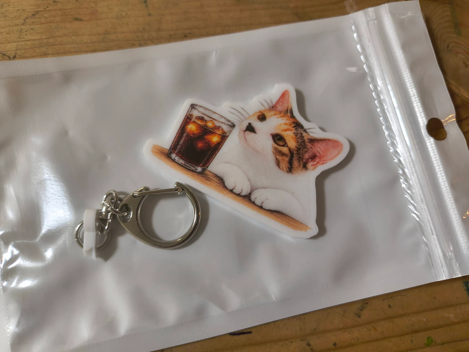 袋に入った猫と珈琲のアクキーと、離れたキーの部分